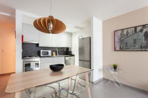 una cucina con tavolo in legno e frigorifero in acciaio inossidabile di FLH Liberdade Terrace Apartment a Lisbona