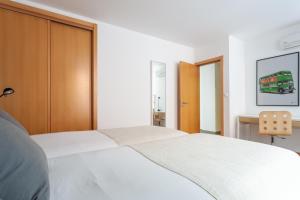 una camera con letto bianco e armadio marrone di FLH Liberdade Terrace Apartment a Lisbona