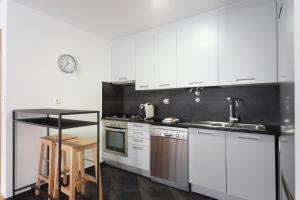 a kitchen with white cabinets and a sink and a counter at FLH Liberdade Contemporary Flat in Lisbon