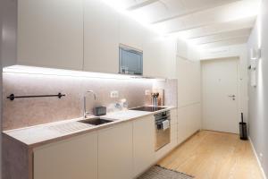 a kitchen with white cabinets and a sink at FLH Bairro Alto Elegant Apartment in Lisbon