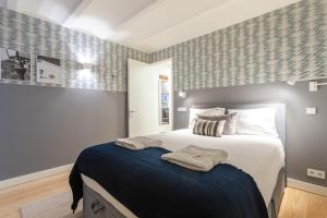 1 dormitorio con 1 cama grande con manta azul en FLH Bairro Alto Elegant Apartment en Lisboa