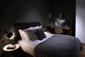 a bedroom with a large bed and a desk at Nôma Living Avenida 60 in Aveiro