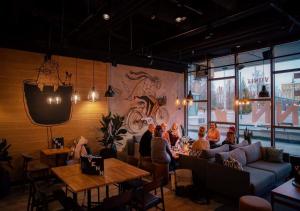 a group of people sitting at tables in a restaurant at Original Sokos Hotel Lappee in Lappeenranta