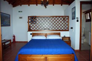 a bedroom with a bed with a blue bedspread at Vila Elena 1astoning view in Steni Vala Alonissos