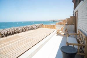 een balkon met een bank en uitzicht op de oceaan bij B&B Las Playitas in Máncora