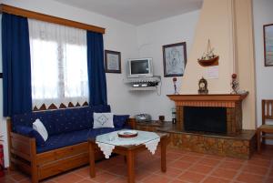 a living room with a blue couch and a tv at Vila Elena 1astoning view in Steni Vala Alonissos