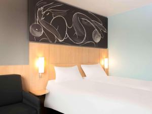 a bedroom with a white bed and a chair at ibis 3 Lacs Neuchâtel in Thielle-Wavre