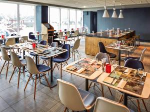 a restaurant with tables and chairs and a bar at ibis London Heathrow Airport in Hillingdon