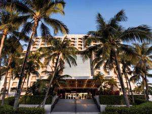 ein Hotel mit Palmen davor in der Unterkunft Pullman Miami Airport in Miami