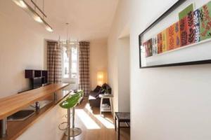 a living room with a couch and a painting on the wall at Barla 3 - a spacious one bedroom apartment near Place Garibaldi in Nice