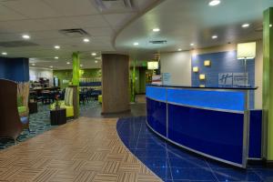 a lobby with a blue counter and a restaurant at Holiday Inn Express & Suites Plant City, an IHG Hotel in Plant City