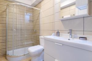 a bathroom with a toilet and a sink and a shower at Villa Remetzo in Skala Potamias +22 photos