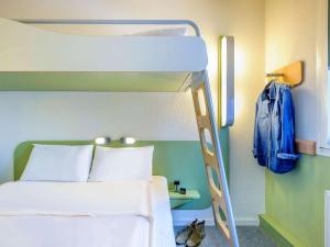 a bedroom with a bunk bed with a blue wall at Ibis budget Hamburg Quickborn in Quickborn