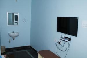 a blue room with a flat screen tv on a wall at SR RESIDENCY in Vellore