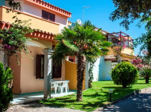 a house with a palm tree in front of it at Residence Oasi Anfiteatro in Porto Ottiolu