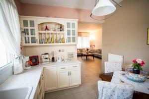 a kitchen with white cabinets and a living room at Anasa Villas in Mithymna