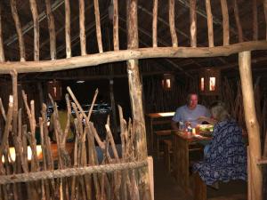 un homme et une femme assis à une table dans une cabine dans l'établissement Brookline Safari Resort, à Uda Walawe