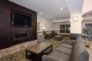 a living room with a couch and a flat screen tv at Holiday Inn Express Pekin - Peoria Area, an IHG Hotel in Pekin Heights