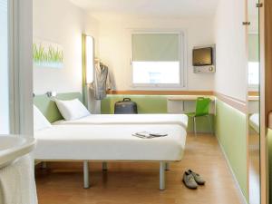 ein Krankenhauszimmer mit einem Bett und einem Waschbecken in der Unterkunft ibis budget Mainz Hechtsheim in Mainz