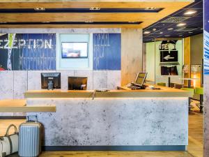 a lobby with a bar with a suitcase in front of it at Ibis budget Hannover Hbf in Hannover