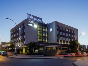 een hotel in een straat waar auto's voor geparkeerd staan bij Ibis Budget Málaga Aeropuerto Avenida de Velazquez in Málaga