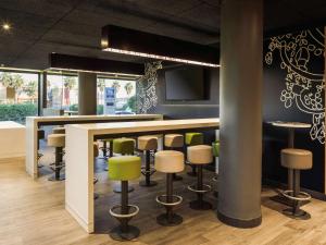 a bar in a restaurant with green bar stools at Ibis Budget Málaga Aeropuerto Avenida de Velazquez in Málaga