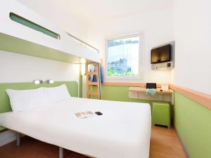 ein Schlafzimmer mit einem Bett, einem Schreibtisch und einem Fernseher in der Unterkunft Ibis Budget Bilbao Arrigorriaga in Arrigorriaga