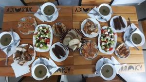 Guest House Lashmina في ميستيا: طاولة مع أطباق من الطعام وأكواب من القهوة