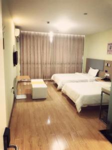 杭州市にある7 Days Inn (Hangzhou Xiaoshan Airport West Gate)のベッド2台と窓が備わるホテルルームです。