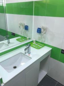 La salle de bains est pourvue d'un lavabo blanc et d'un miroir. dans l'établissement 7 Days Inn (Hangzhou Xiaoshan Airport West Gate), à Hangzhou