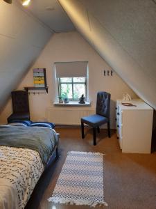 a bedroom with a bed and a chair in a attic at familiehuis Benboverijssel in Haaksbergen