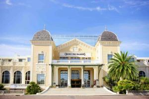 a large white building with a sign on it at Studio centre de Hyeres pour 4 personnes piscine et tennis in Hyères