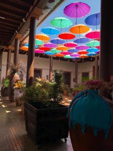 een bos van kleurrijke paraplu's hangend aan een plafond bij Hotel Villa de Flores in Uruapan del Progreso