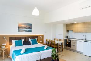 a bedroom with a large bed and a kitchen at Helios Bay Hotel and Suites in Paphos
