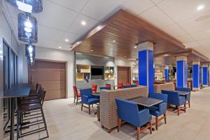 a dining area with blue chairs and tables in a lobby at Holiday Inn Express and Suites Chanute, an IHG Hotel in Chanute