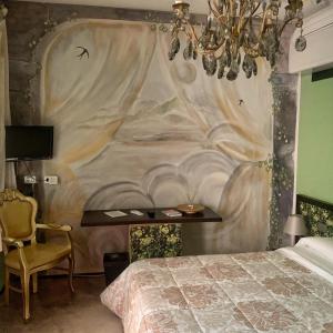 a bedroom with a bed with a painting on the wall at Locanda Cortiletto d'Alba in Alba