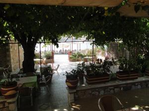 a patio with tables and chairs and a tree at Porto Sabatiki in Sampatiki