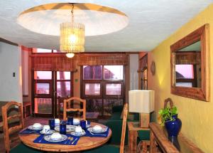 una sala da pranzo con tavolo e lampadario pendente di Villas El Rancho Green Resort a Mazatlán