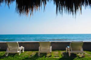 three chairs sitting in front of the ocean at Villas El Rancho Green Resort in Mazatlán +64 photos