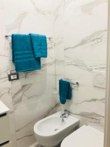 a bathroom with a white toilet and blue towels at Frida Kahlo appartament in Lacco Ameno +44 photos