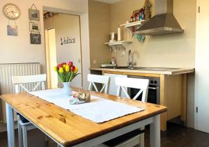 una cocina con una mesa de madera con flores. en Ostseehaus Oe, en Sierksdorf
