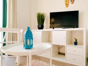 un soggiorno bianco con TV e tavolo di Endless Summer apartment (San valentin) a Corralejo