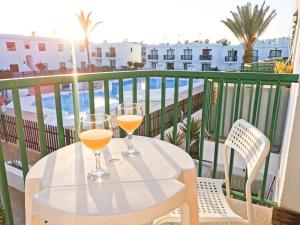 2 bicchieri di succo d'arancia seduti su un tavolo sul balcone di Endless Summer apartment (San valentin) a Corralejo