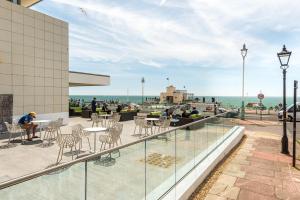 a balcony with tables and chairs on a building at Holiday Inn Brighton Seafront by IHG in Brighton & Hove