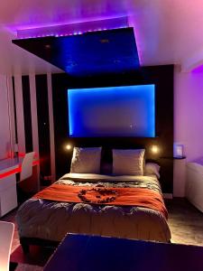 Schlafzimmer mit einem Bett mit blauer und violetter Beleuchtung in der Unterkunft ADsweet in Épernay