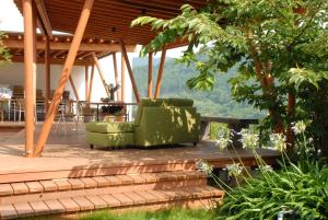 a deck with two green chairs and a table at Zen no Yu in Kawazu