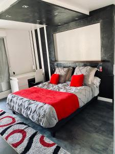 ein Schlafzimmer mit einem großen Bett mit roten Kissen in der Unterkunft ADsweet in Épernay