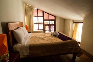 Un pat sau paturi într-o cameră la Askha Cusco