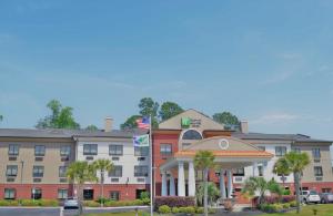 un edificio de hotel con palmeras delante en Holiday Inn Express & Suites Pensacola West I-10, an IHG Hotel en Pensacola