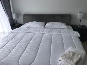 a large white bed with white sheets and pillows at Centara Avenue a4,Near WALKING STREET,freePOOL,GYM in Pattaya